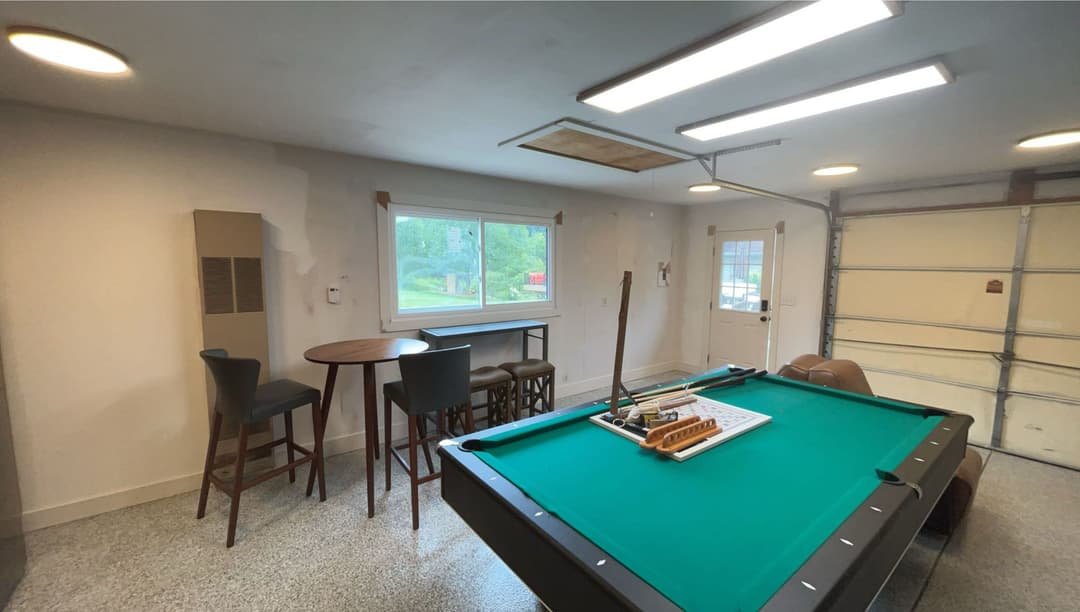 Home game room featuring a pool table, bar seating, and a window for natural light.