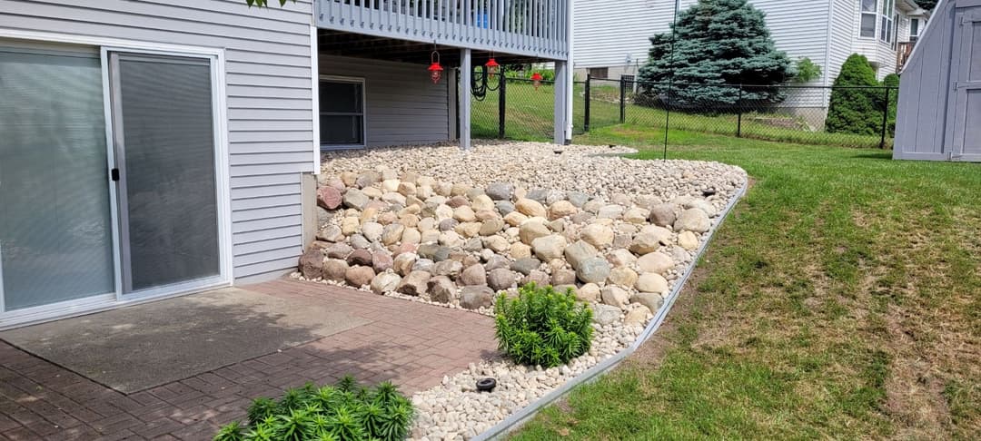 Decorative stone landscaping with rocks and plants, enhancing outdoor space aesthetics.